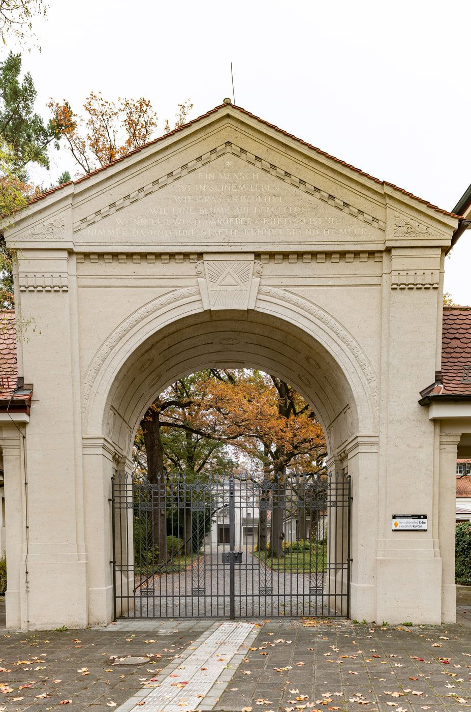 Monumentales helles Eingangstor mit Rundbogen, Dreiecksgiebel und schmiedeeisernem Gitter auf Südfriedhof Nürnberg